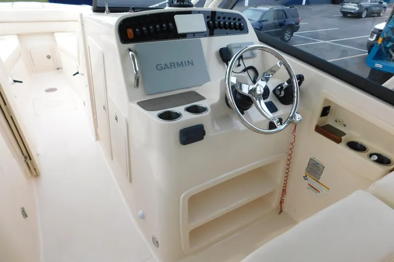 Slide: The Image of 2015 Grady-White Freedom 307 boat helm with Garmin navigation system and steering wheel. - 20