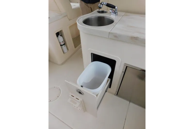 Slide: The Image of 2015 Grady-White Freedom 307 boat interior with sink and pull-out trash bin. - 37