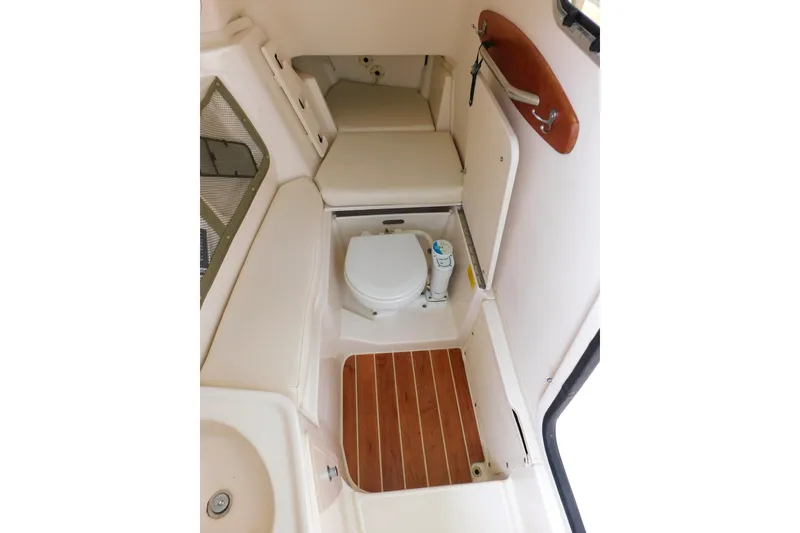 Slide: The Image of 2015 Grady-White Freedom 307 boat interior with compact marine toilet and wooden flooring. - 41