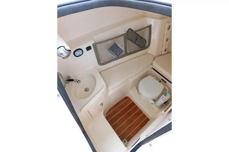 Slide: The Image of Interior of 2015 Grady-White Freedom 307 boat, featuring a compact bathroom with sink and toilet. - 43