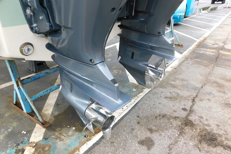 Slide: The Image of Dual outboard motors on a 2015 Grady-White Freedom 307 boat in a parking area. - 8