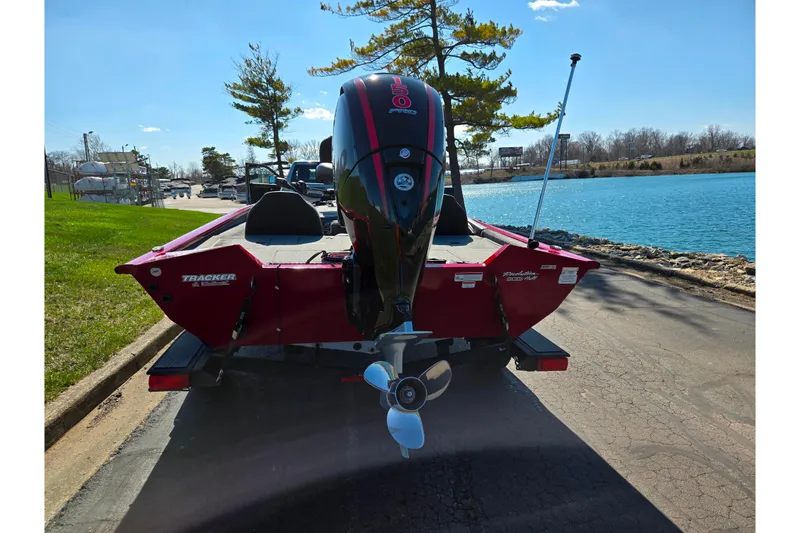 Slide: The Image of 2024 Tracker Pro Team 195 TXW Tournament Edition boat by a lakeside road. - 2
