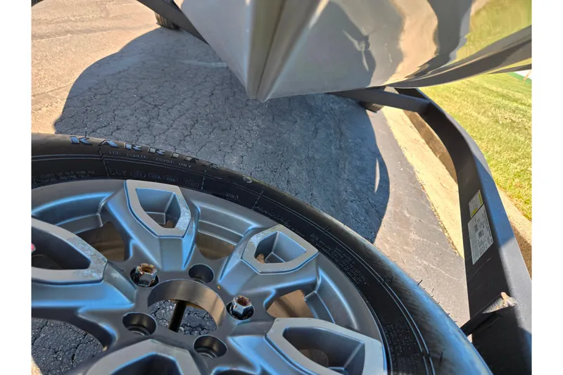 Slide: The Image of 2024 Tracker Pro Team 195 TXW Tournament Edition trailer wheel and hull close-up. - 7