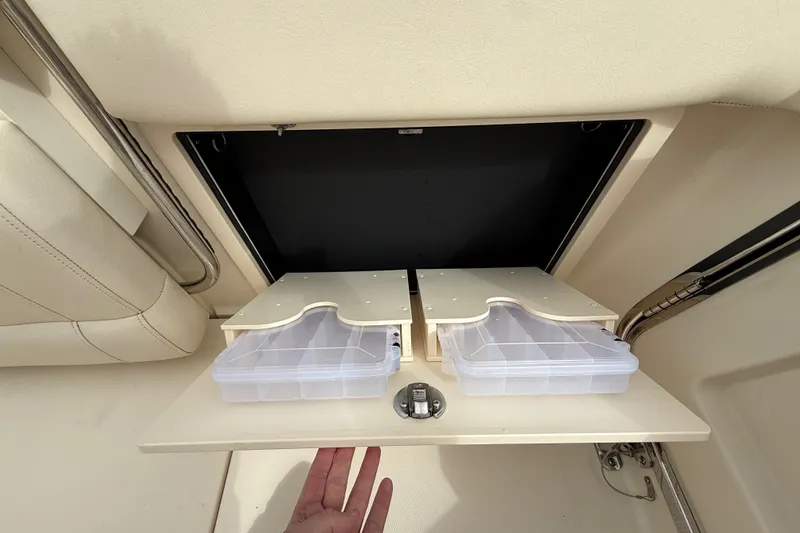 Slide: The Image of Storage compartment on a 2020 Grady-White Freedom 325 boat with organized containers. - 32