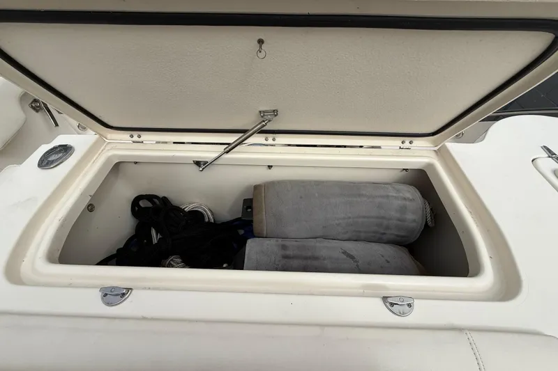 Slide: The Image of Open storage compartment on 2020 Grady-White Freedom 325 boat with ropes and fenders inside. - 35