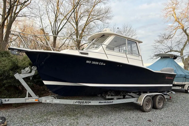 The Image of 2020 NorthCoast 235 HT boat on trailer in parking lot, clear sky background. - 0