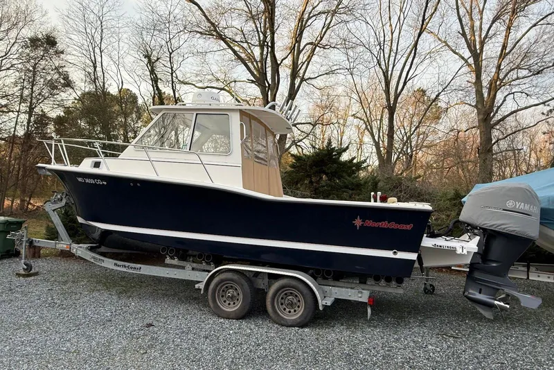 Slide: The Image of 2020 NorthCoast 235 HT boat on trailer, parked outdoors under clear sky. - 1