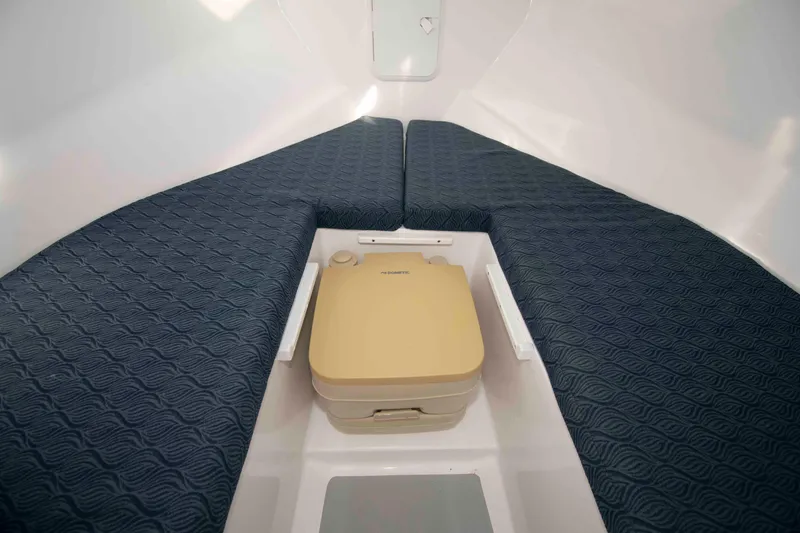 Slide: The Image of Interior cabin of 2020 NorthCoast 235 HT boat with blue cushions and portable toilet. - 15