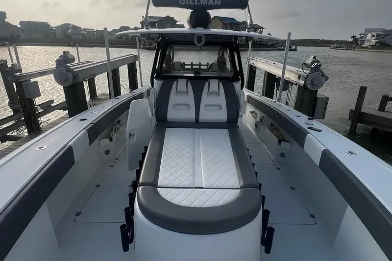 Slide: The Image of Freeman 37VH 2022 boat with sleek seating, docked by waterfront homes. - 5