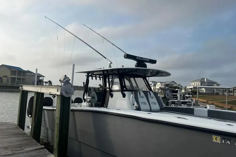 Slide: The Image of 2022 Freeman 37VH boat docked, featuring fishing rods and coastal homes in the background. - 6