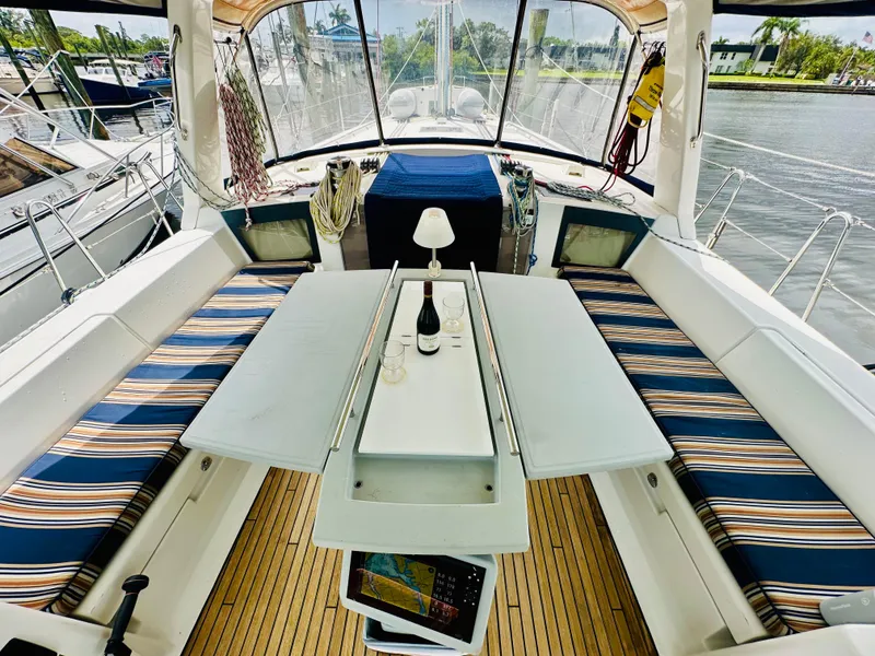 Slide: The Image of Cockpit of 2015 Beneteau Oceanis 45 with striped seating and table setup. - 14