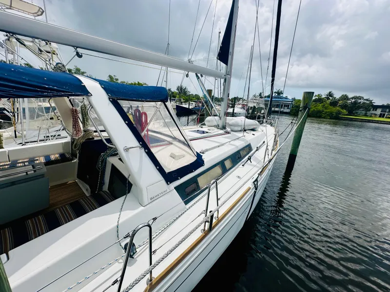Slide: The Image of 2015 Beneteau Oceanis 45 sailboat docked on a calm waterway under cloudy skies. - 19