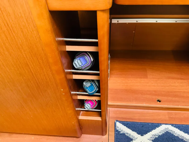 Slide: The Image of Wooden interior storage with water bottles on a 2015 Beneteau Oceanis 45 yacht. - 44