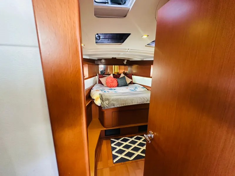 Slide: The Image of Cozy cabin interior of 2015 Beneteau Oceanis 45 sailboat with bed and wooden finish. - 47