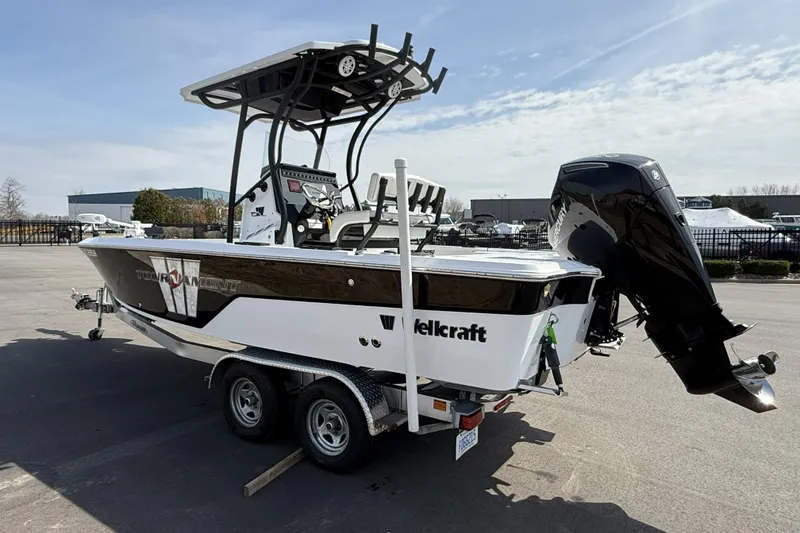 Slide: The Image of 2019 Wellcraft 221 Bay boat on trailer, featuring a powerful outboard motor. - 3