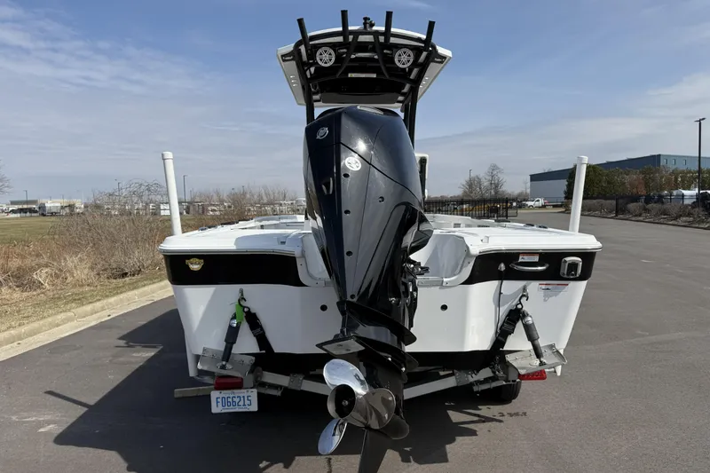 Slide: The Image of 2019 Wellcraft 221 Bay boat with outboard motor on a trailer, parked outdoors. - 5