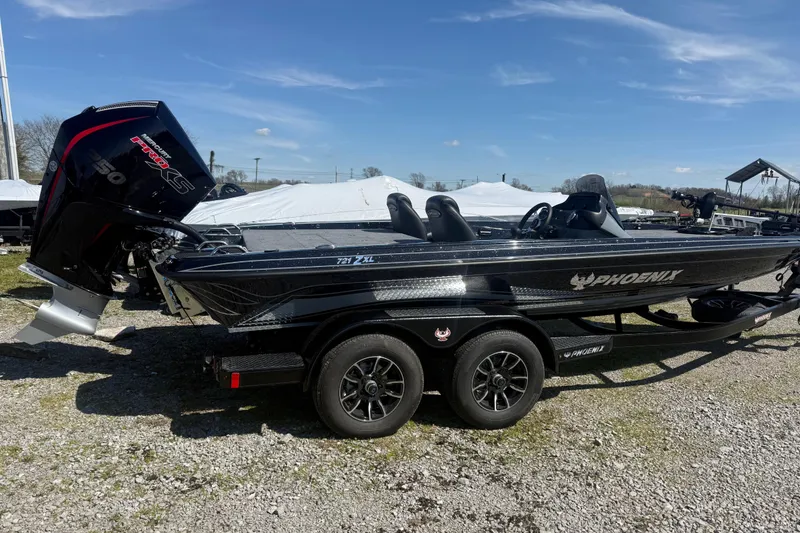 Slide: The Image of 2026 Phoenix 721 ZXL boat with powerful engine, parked on gravel under clear blue sky. - 6