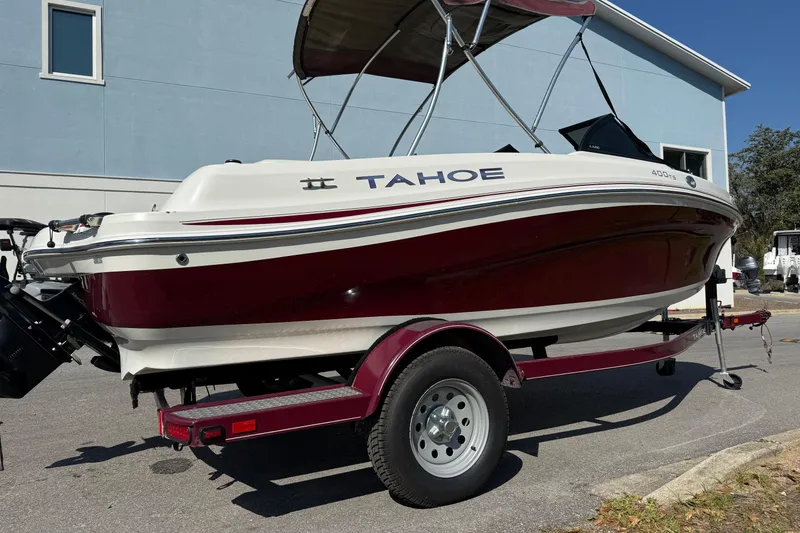 Slide: The Image of 2016 Tahoe 400 TS boat on trailer, red and white design, parked outdoors. - 3