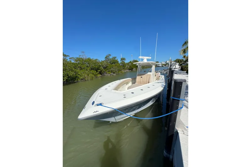 Slide: The Image of 2021 SeaVee Boats 370Z docked in a serene waterway under clear blue skies. - 8