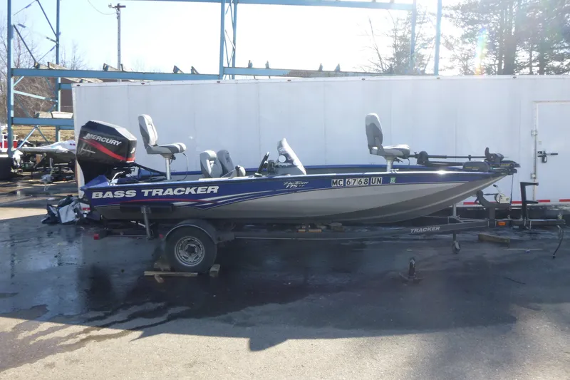 The Image of 2011 Tracker Pro Team 175 TF bass boat on trailer, parked outdoors. - 1