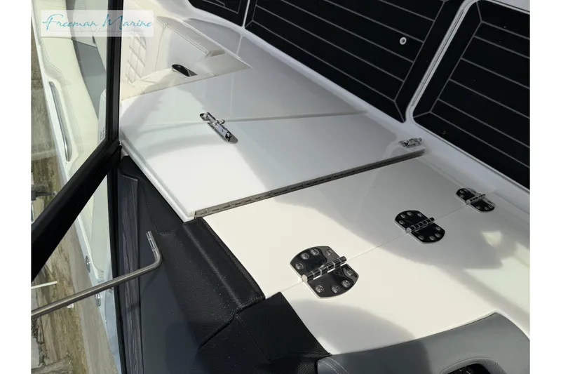 Slide: The Image of 2021 Cobalt R30 boat interior with white seating and storage compartments. - 28
