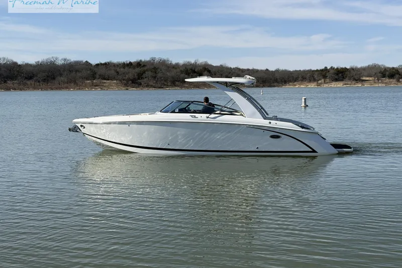 Slide: The Image of 2021 Cobalt R30 boat cruising on a calm lake under a clear sky. - 3