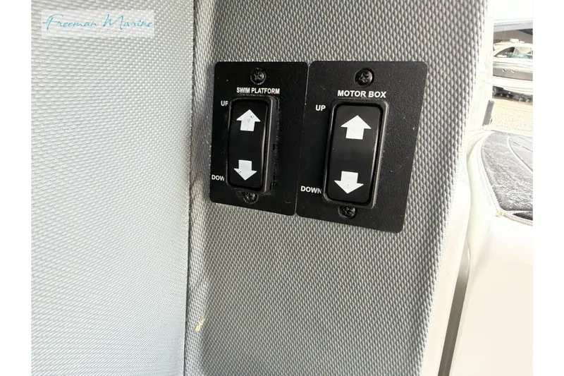 Slide: The Image of Control switches for swim platform and motor box on a 2021 Cobalt R30 boat. - 36