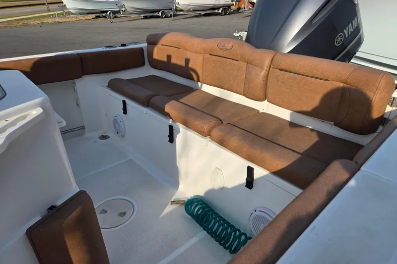 Slide: The Image of 2019 Sea Hunt Ultra 234 boat interior with brown cushioned seating and Yamaha engine. - 12