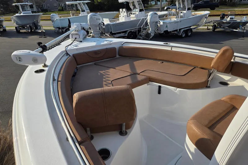 Slide: The Image of 2019 Sea Hunt Ultra 234 boat with brown seating, docked among other boats. - 6