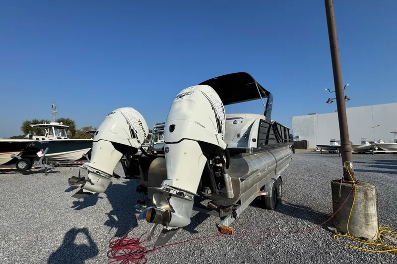 Slide: The Image of 2018 South Bay 725RS pontoon boat with dual outboard motors in a gravel lot. - 12