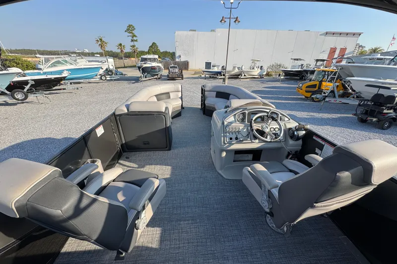 Slide: The Image of 2018 South Bay 725RS pontoon boat interior with steering console and seating, displayed outdoors. - 25