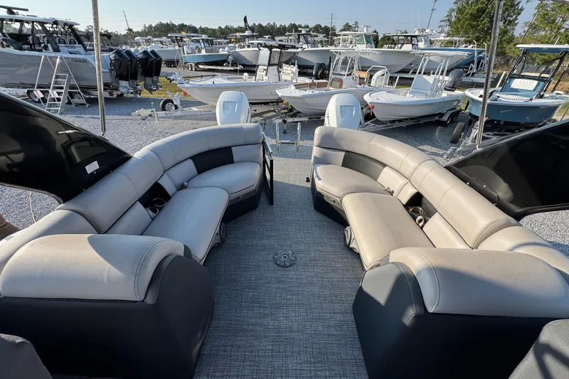 Slide: The Image of 2018 South Bay 725RS pontoon boat interior with plush seating, docked among other boats. - 26