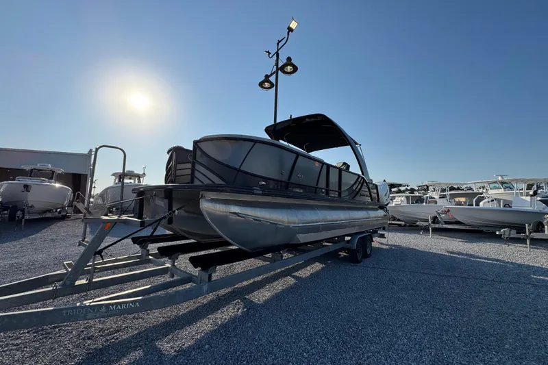 Slide: The Image of 2018 South Bay 725RS pontoon boat on trailer under bright sun at marina. - 4