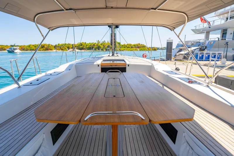 Slide: The Image of Grand Soleil 58 yacht cockpit with wooden table, docked by clear blue water, 2016 model. - 31