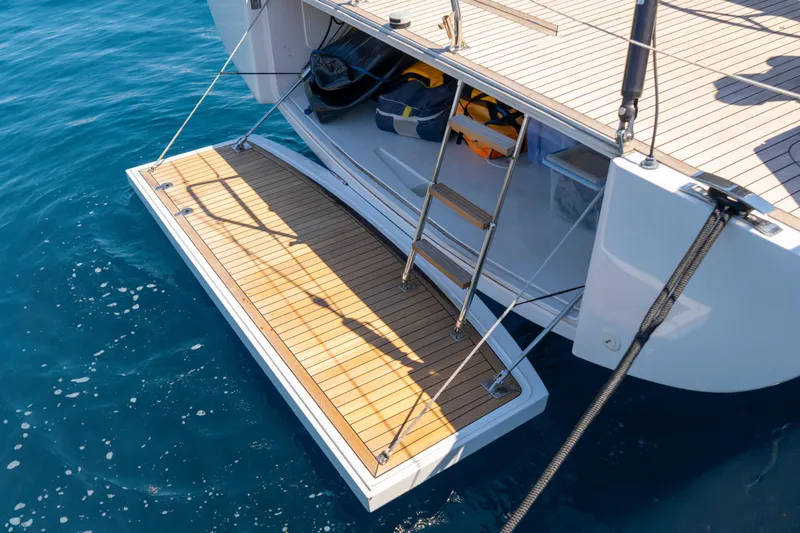 Slide: The Image of Grand Soleil 58 yacht's teak swim platform and ladder, 2016 model, on clear blue water. - 35