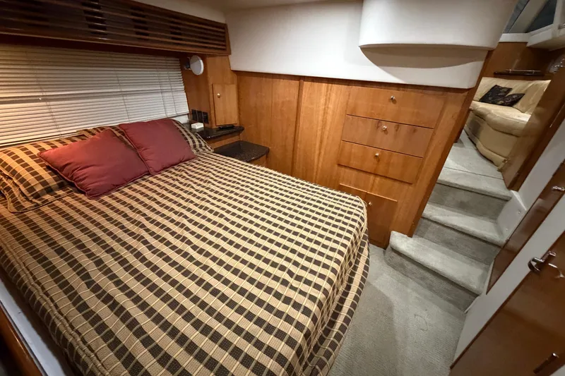 Slide: The Image of Interior of 2001 Carver 444 Cockpit Motor Yacht with cozy bedroom and wooden cabinetry. - 15