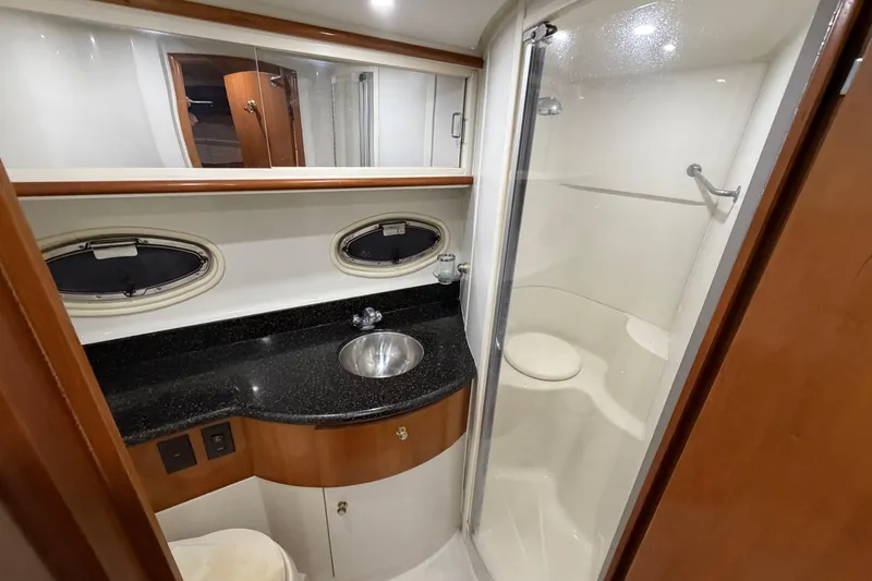 Slide: The Image of 2001 Carver 444 Cockpit Motor Yacht bathroom with shower, sink, and porthole windows. - 16