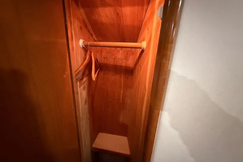 Slide: The Image of Wooden closet interior on 2001 Carver 444 Cockpit Motor Yacht with hangers and shelf. - 29