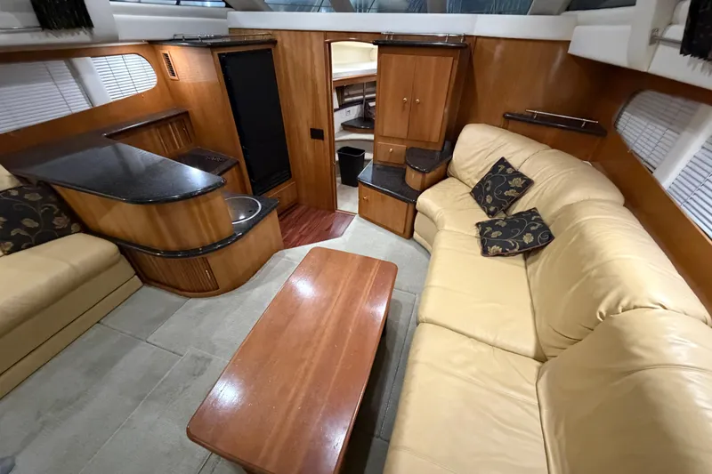 Slide: The Image of Interior of 2001 Carver 444 Cockpit Motor Yacht with beige seating and wooden cabinetry. - 5