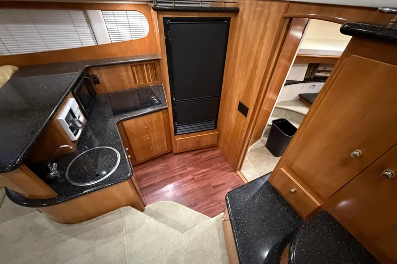 Slide: The Image of Interior of 2001 Carver 444 Cockpit Motor Yacht with modern kitchen amenities. - 6