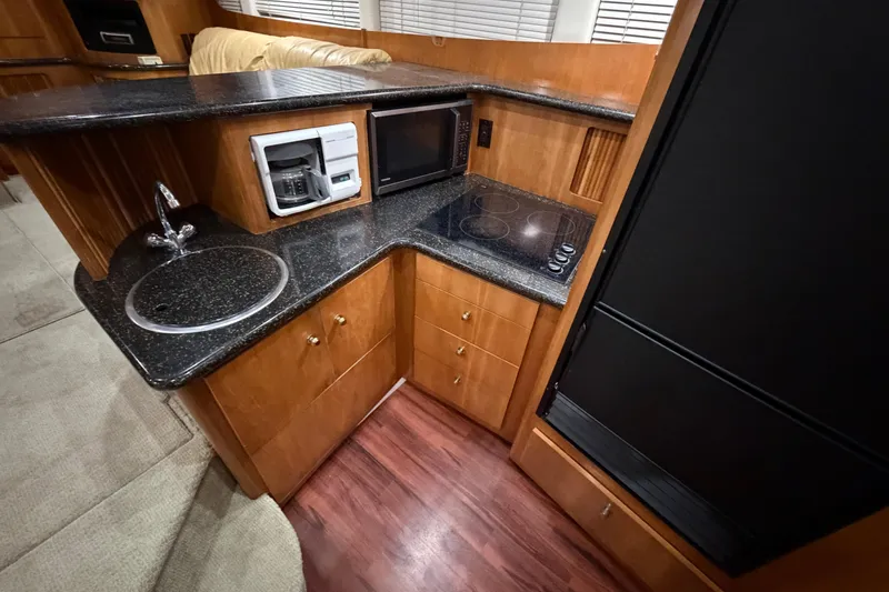 Slide: The Image of 2001 Carver 444 Cockpit Motor Yacht kitchen with sink, stove, and microwave. - 7
