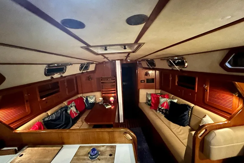 Slide: The Image of Interior of a 1987 Sabre 42 yacht with cozy seating and wooden accents. - 12