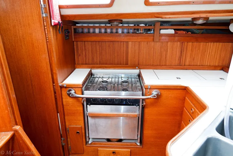 Slide: The Image of 1987 Sabre 42 yacht interior kitchen with stove and wooden cabinetry. - 14