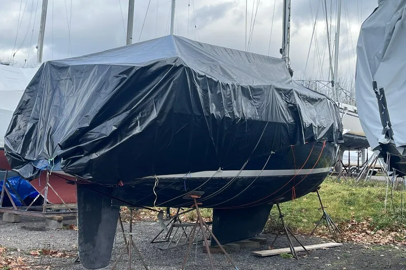 Slide: The Image of 1987 Sabre 42 sailboat covered with tarp, stored on land with stands. - 29