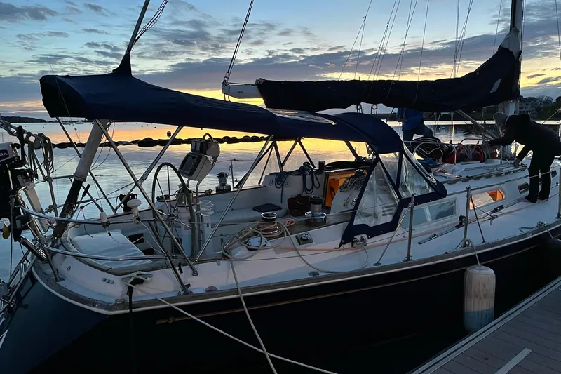 Slide: The Image of 1987 Sabre 42 sailboat docked at sunset, featuring a sleek design and spacious deck. - 3
