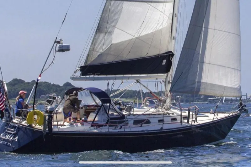 Slide: The Image of 1987 Sabre 42 sailboat cruising on open water with full sails. - 5
