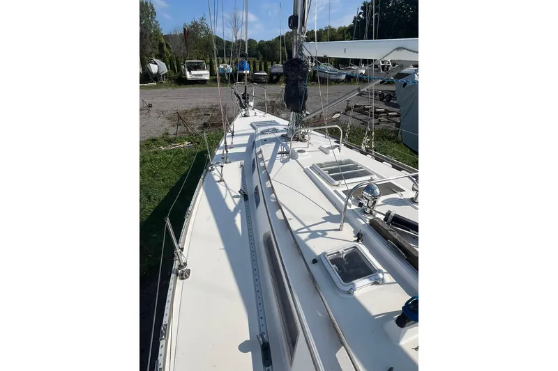 Slide: The Image of 1987 Sabre 42 sailboat deck view with rigging and hatches in a marina setting. - 7