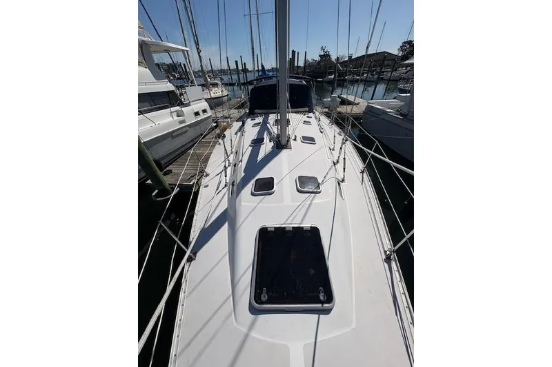 Slide: The Image of Deck view of a 2002 Catalina 400 MkII sailboat docked at a marina. - 16