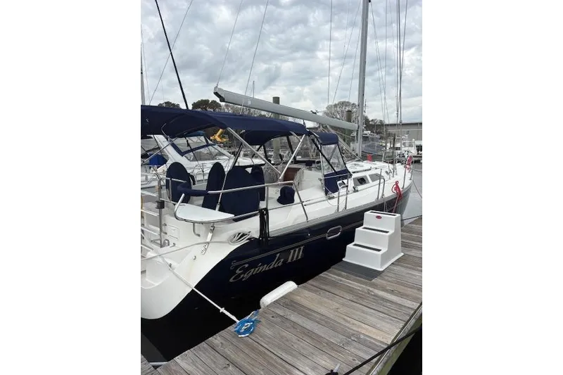Slide: The Image of 2002 Catalina 400 MkII sailboat docked with blue canopy and white hull. - 2