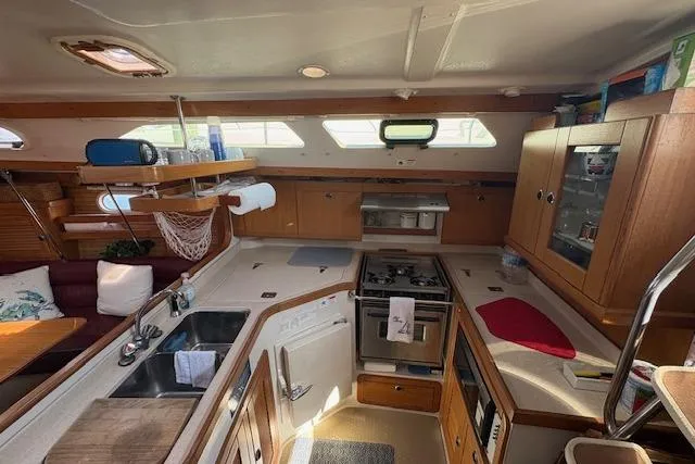 Slide: The Image of Interior of 2002 Catalina 400 MkII sailboat, featuring a well-equipped kitchen and cozy seating area. - 26
